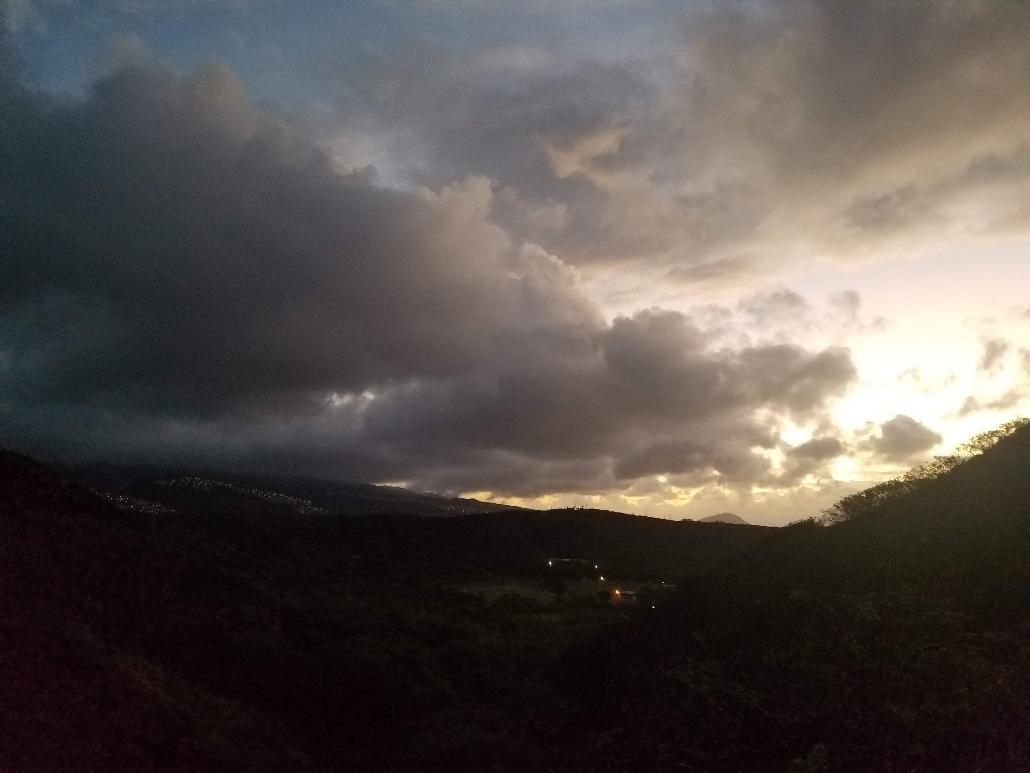 the sun rising over one of the crests of Diamond Head crater in Honolulu, HI
