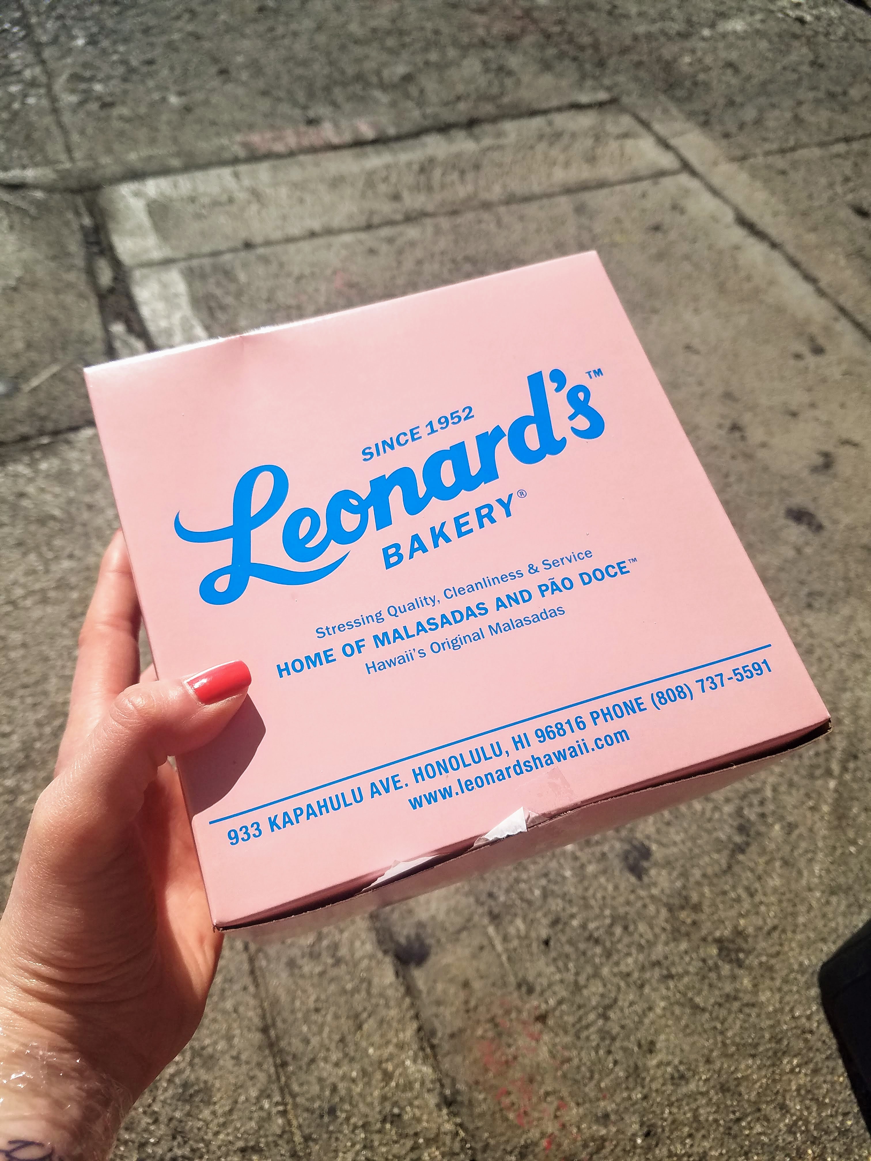 a pink square box with Leonard's bakery written in blue.